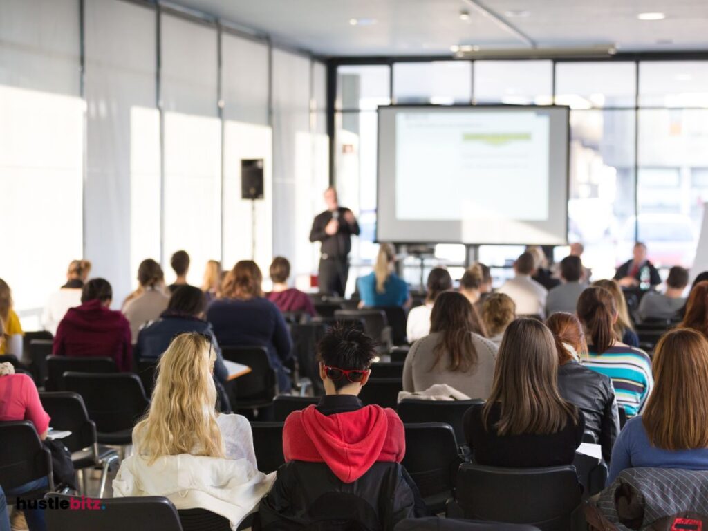 A group of people listen to the man talking in front of them