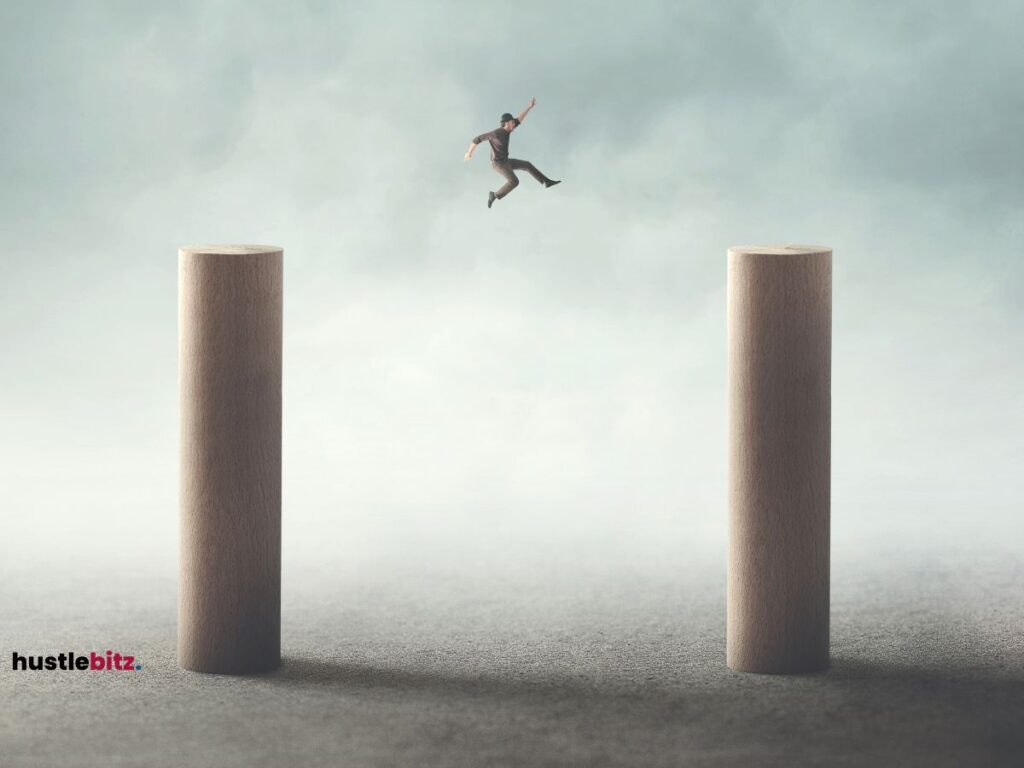 A man jumping from one cylinder shape to another.