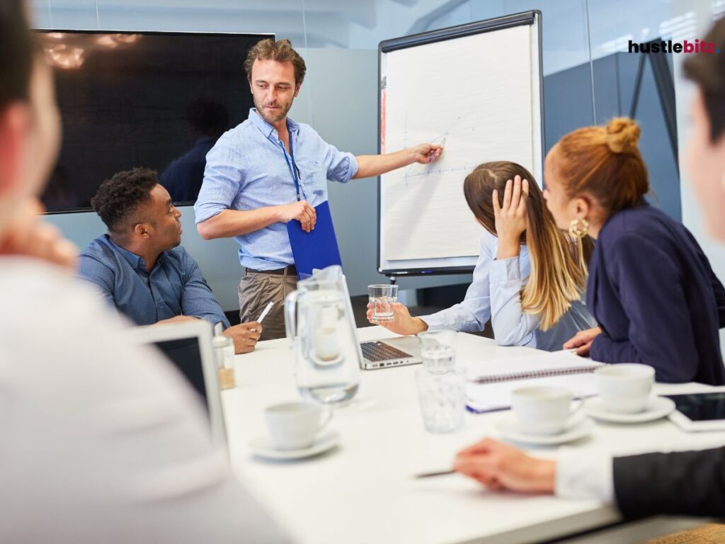 A group of people listen to the man talking in front of them