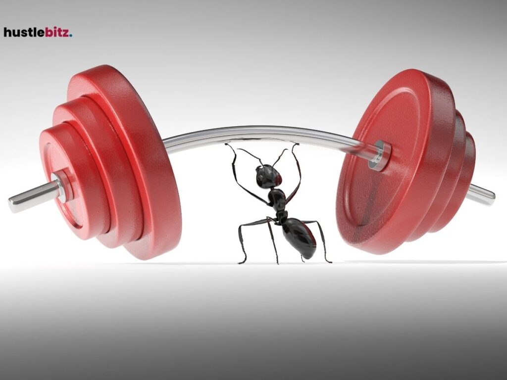 A black ant lifting a large, red barbell.