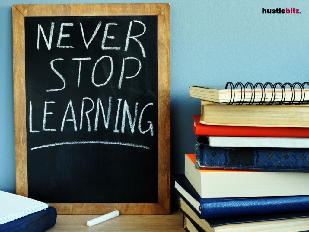 A chalkboard with the words "NEVER STOP LEARNING" written alongside a stack of books.