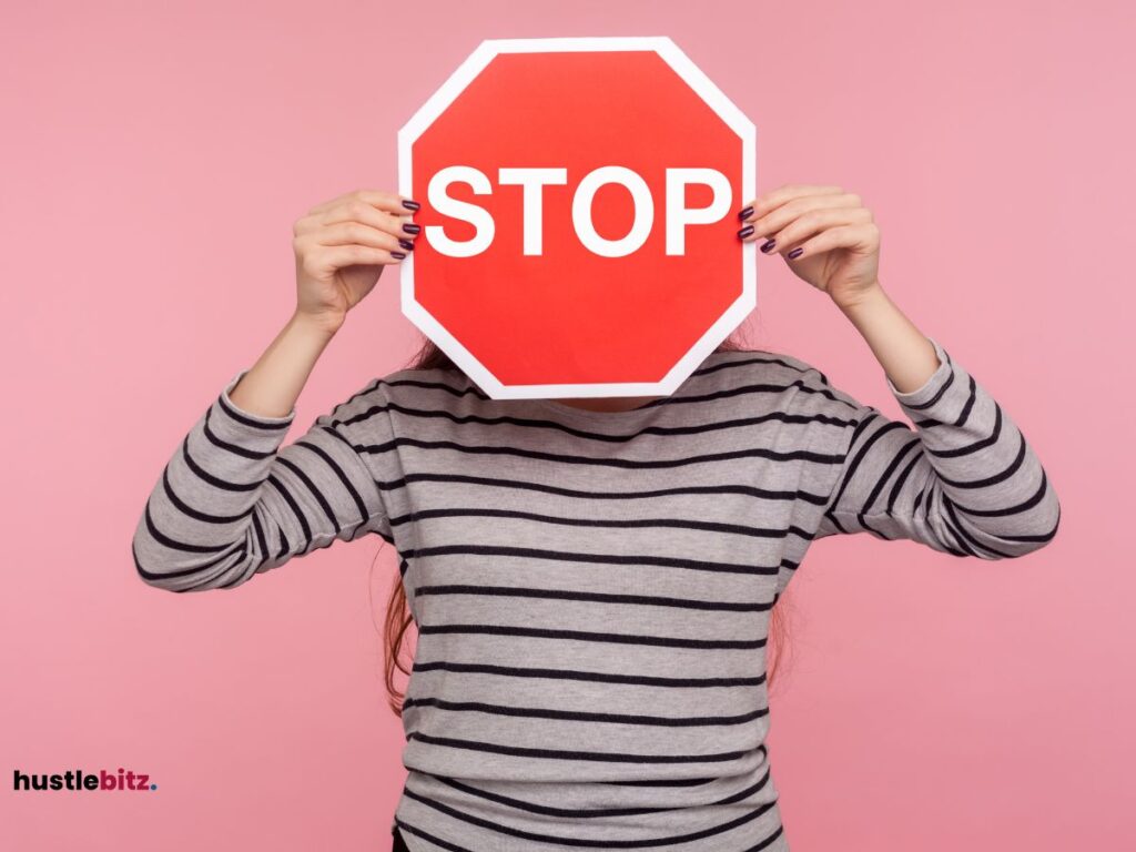 A woman holding a red stop sign in front of her face.