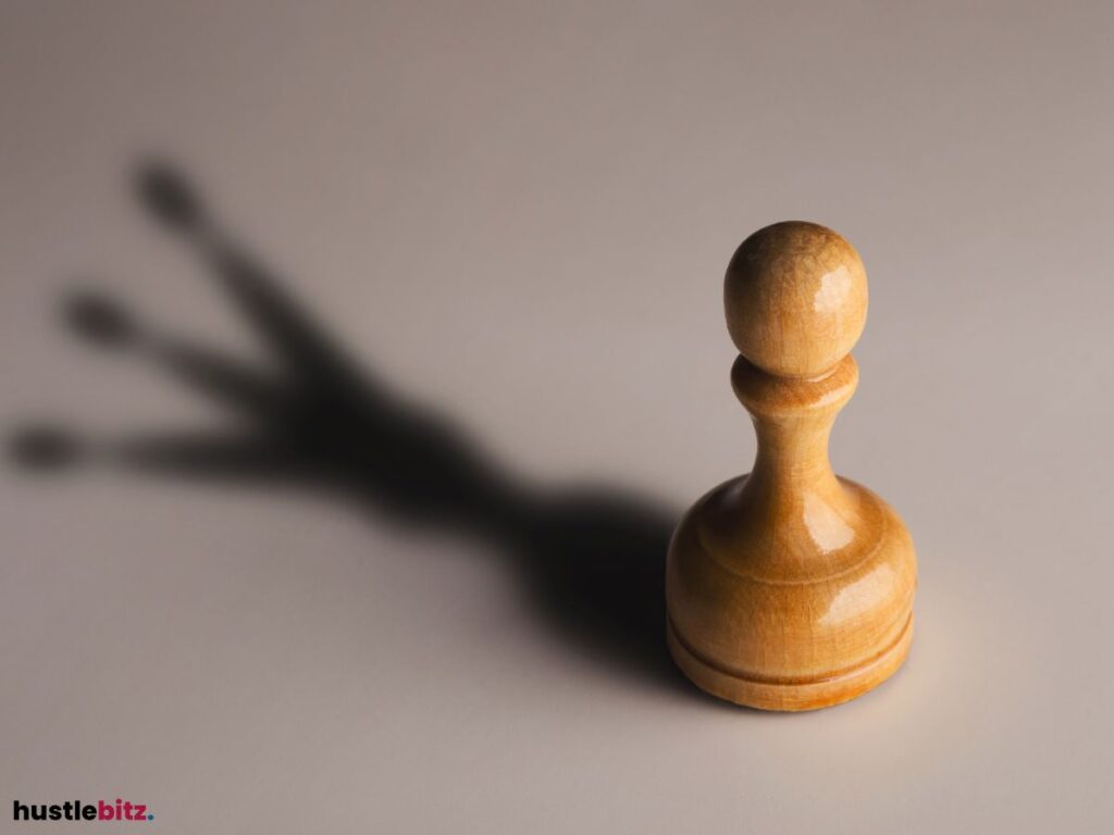 A wooden pawn casts a shadow resembling a crown.