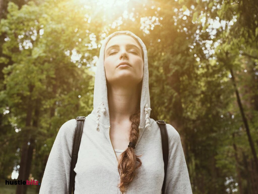 A woman close her eyes and feel the seasons inside the nature