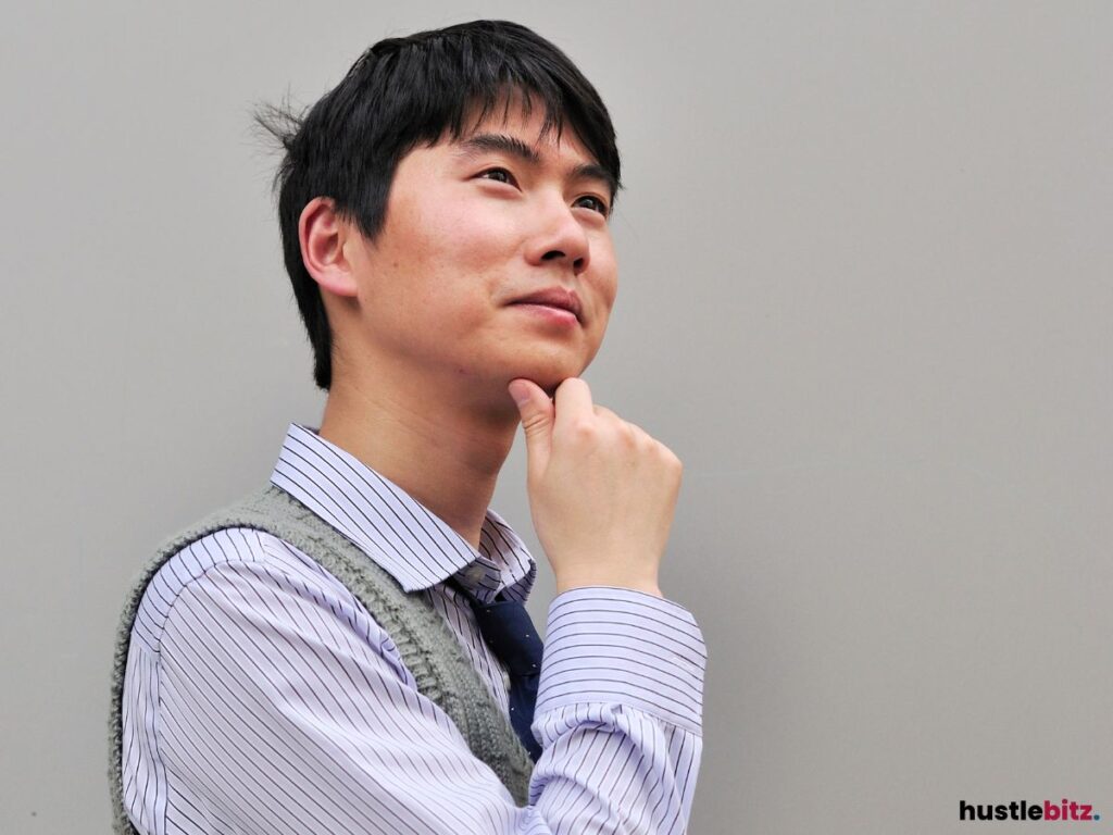 A man in deep thought with his hand on his chin, looking upward.