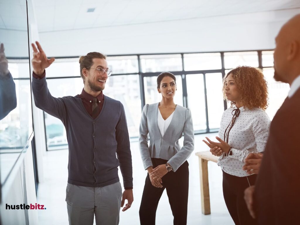 A group of people talking and pointing the monitor