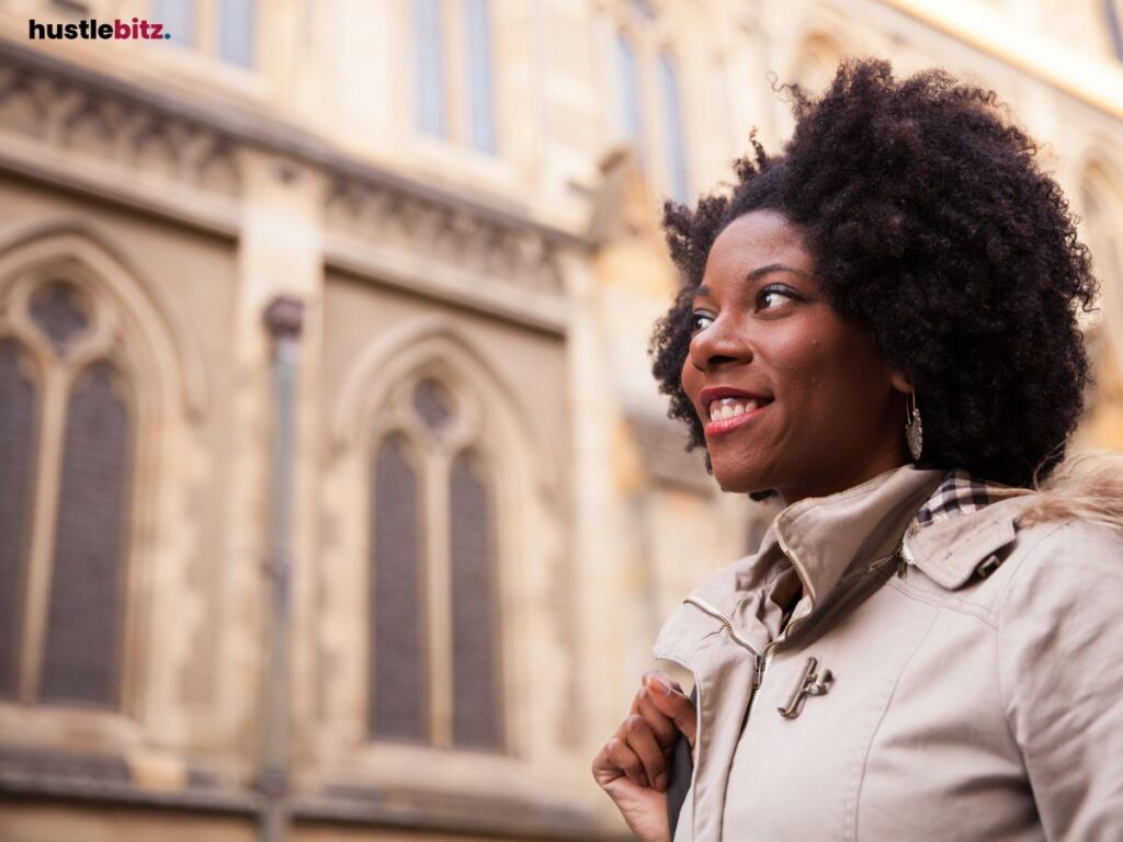 Woman smiling while walking outside a building.