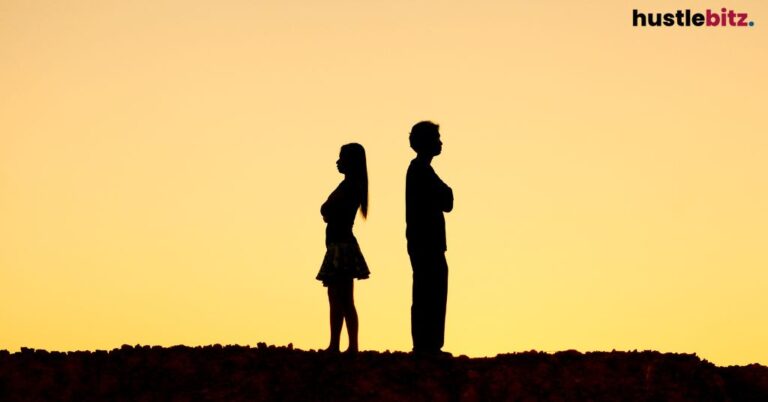 Silhouetted couple standing apart at sunset.
