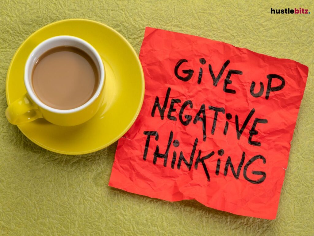 A cup of coffee with a red sticky note beside that says "GIVE UP NEGATIVE THINKING".