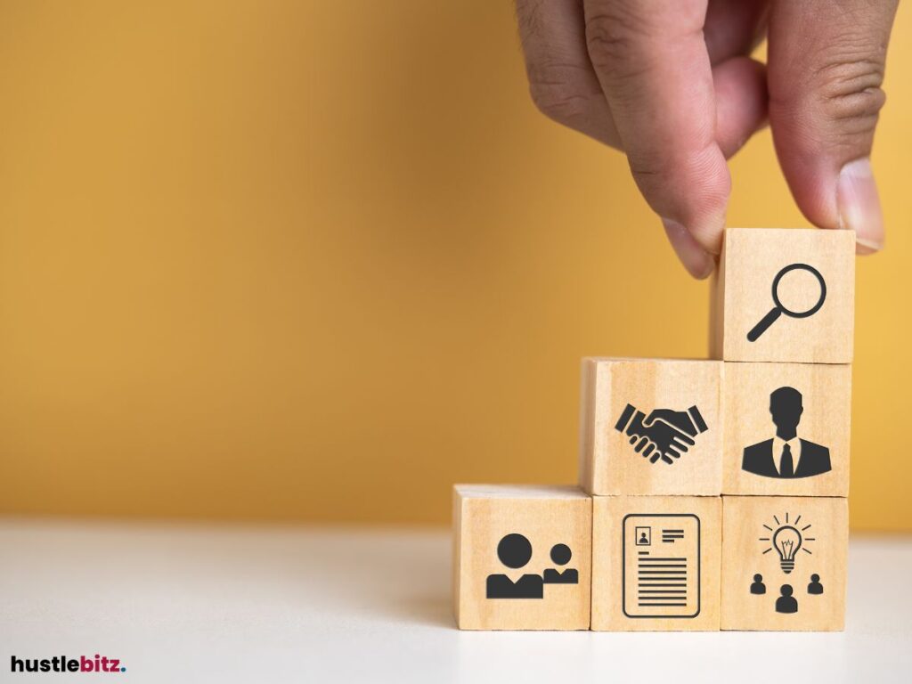 Hand stacking wooden blocks with icons for business and teamwork.