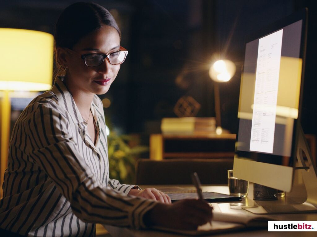 A woman working late at her computer, focused and diligent.
