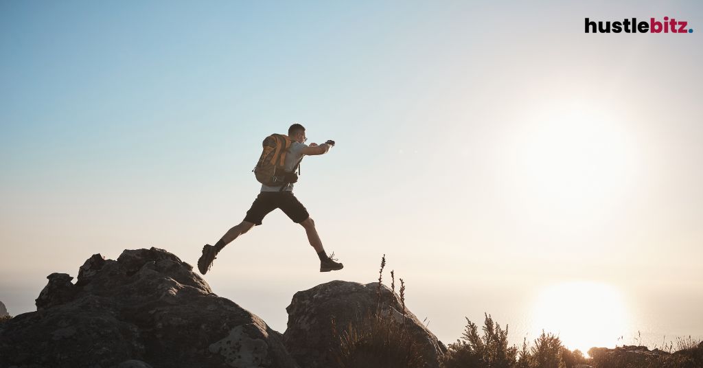 A person leaping between two rocks during a hike.
