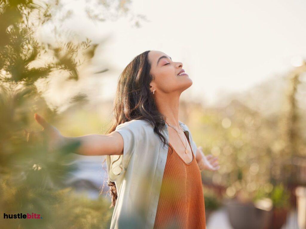 A woman raise her two hands and feel the wind in the nature