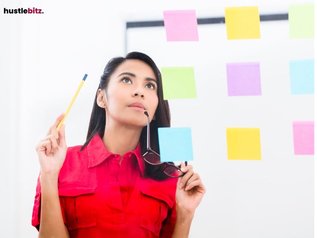 Woman thinking while looking at sticky notes on a glass wall.