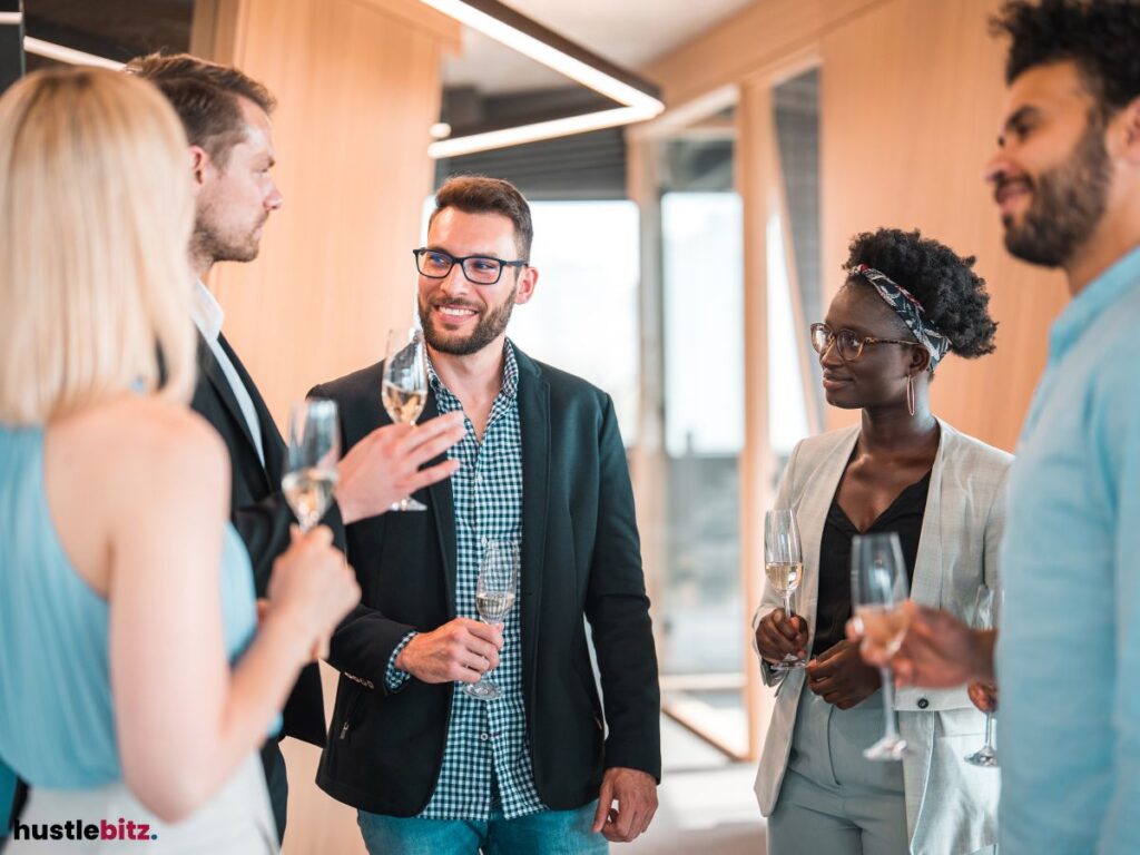 A group of professionals holding drinks and chatting.