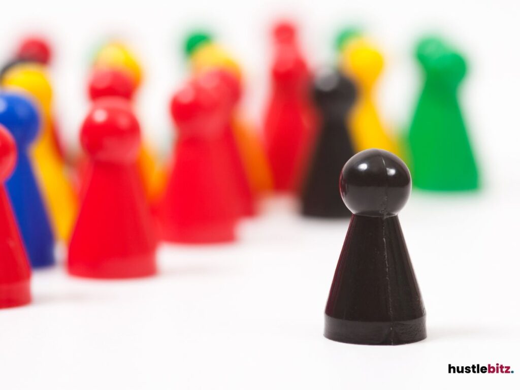 A black pawn figure in front of colorful pawns.