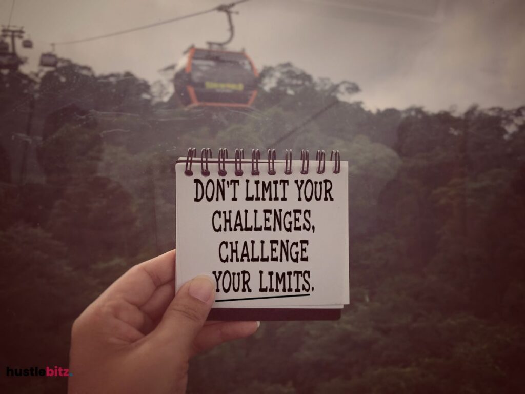 A hand holding a small book with motivational word