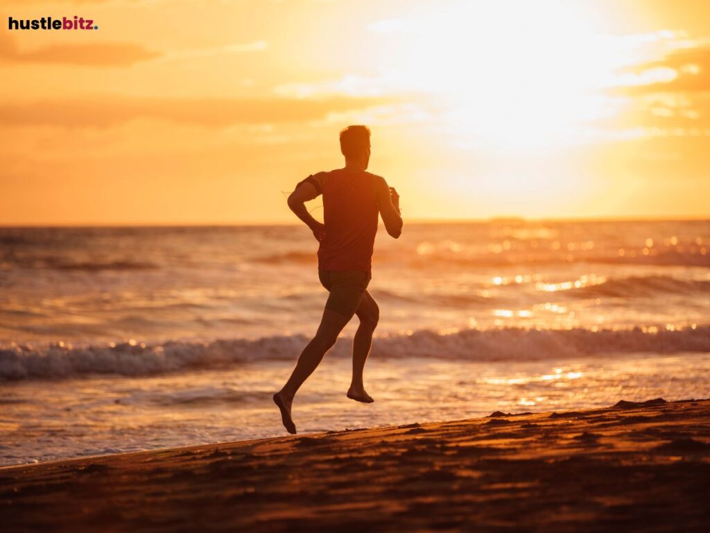 A man running along a beach at sunset.