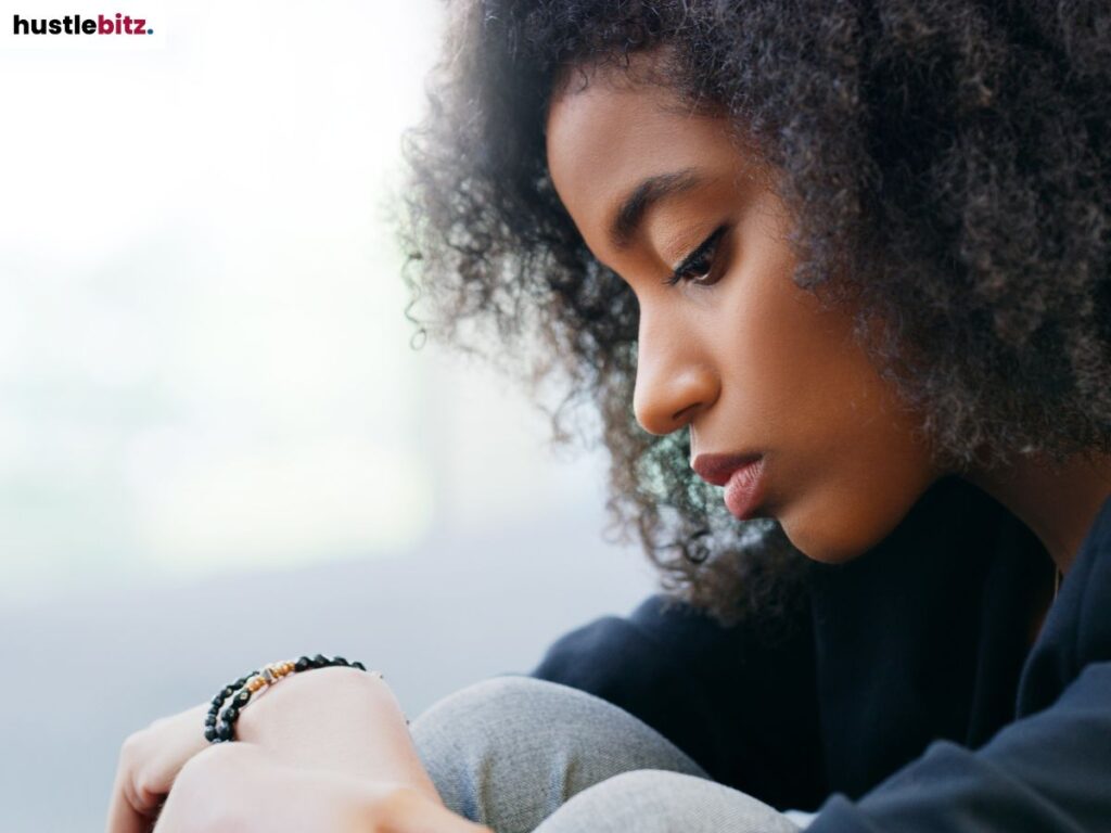 A woman in deep thought, leaning forward with her head down.
