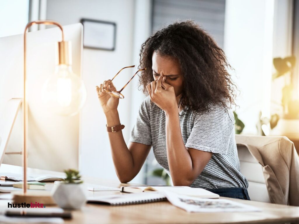 a woman holding an eyeglass in front of the monitor