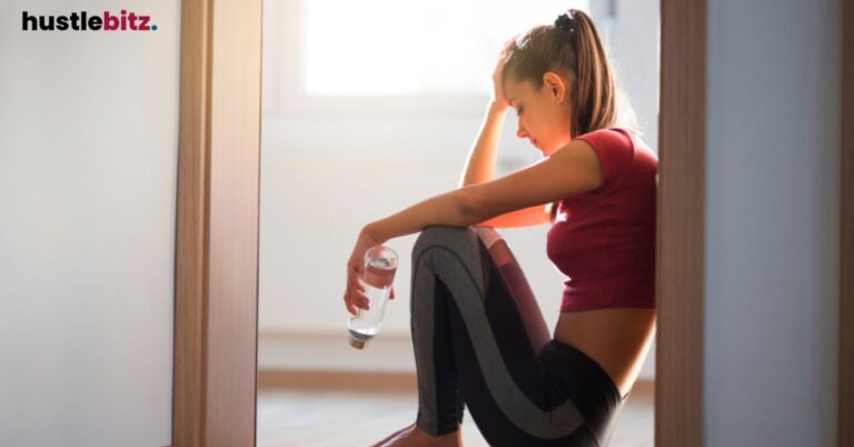 Woman sitting on the floor with water bottle, reflecting.