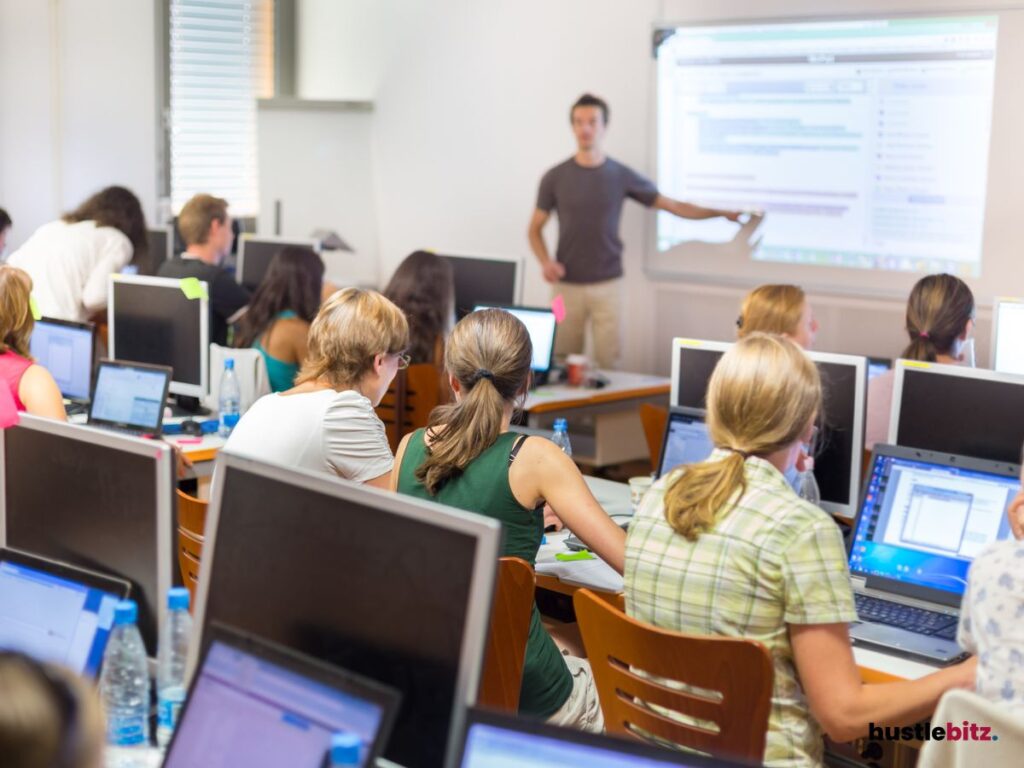 A group of people using laptop and looking at the presentation
