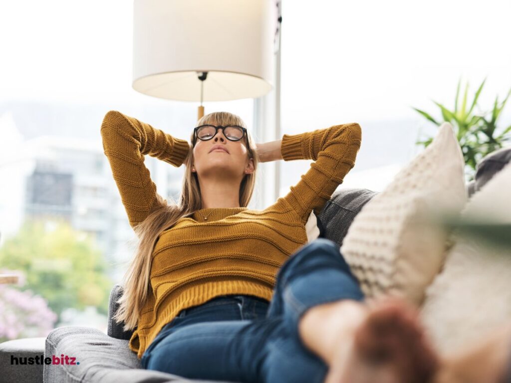 A woman lay down the couch with pillows and lamp