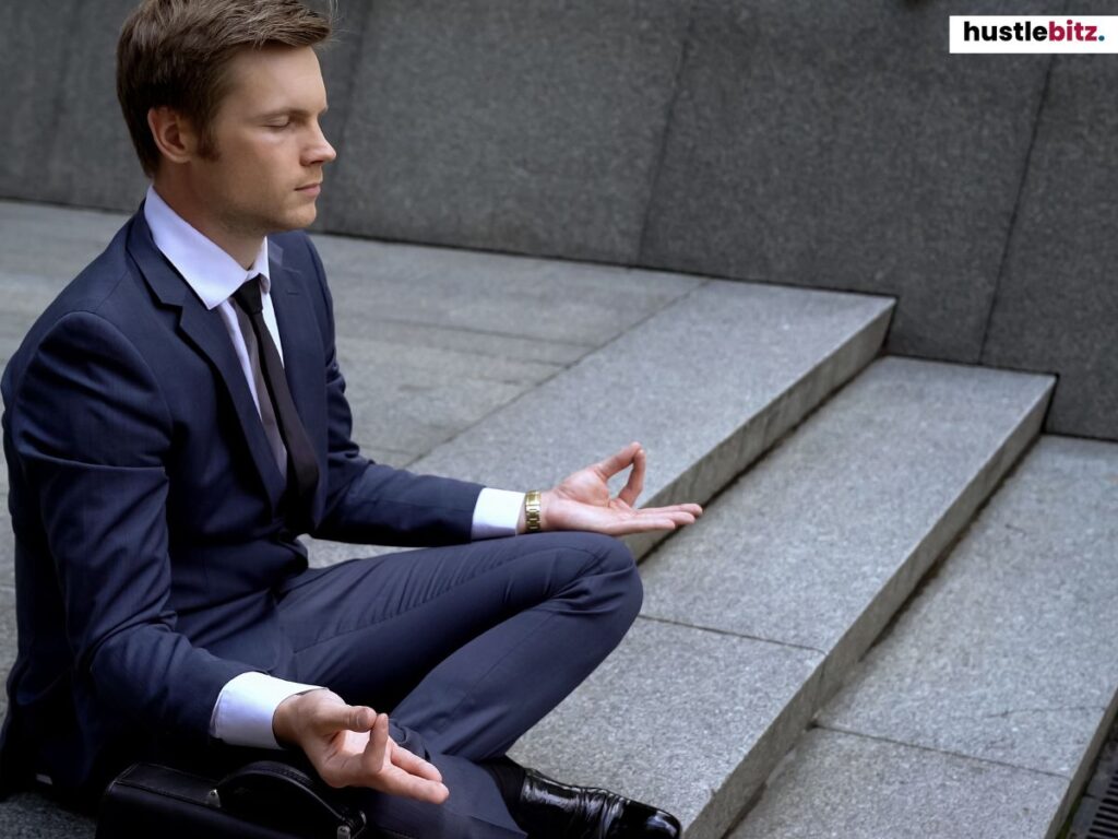 A man meditating on stairs in a suit, finding balance and calm.