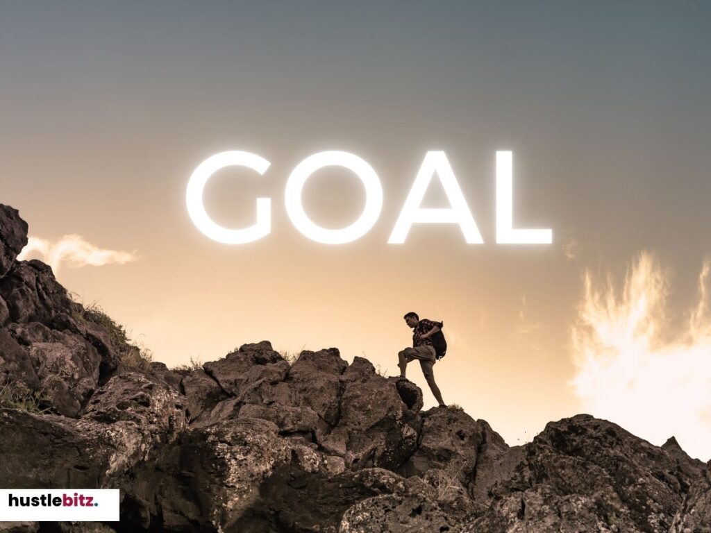 A person climbing rocky terrain with the word "GOAL" shining above.