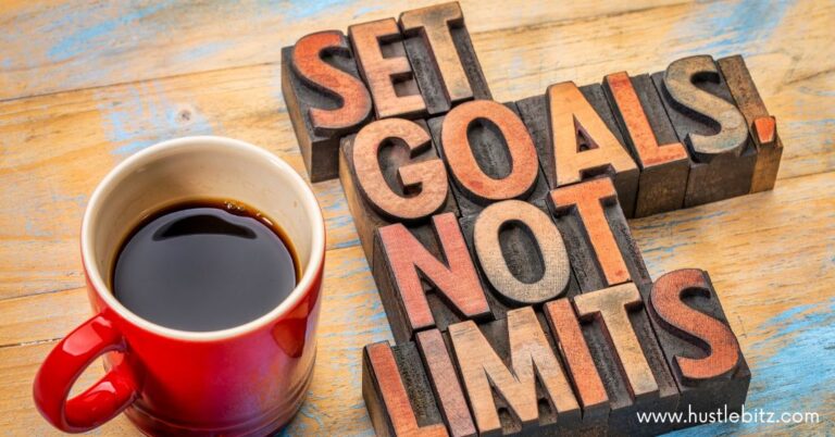 A cup of coffee on the table and a wooden carved text "SET GOALS NOT LIMITS"