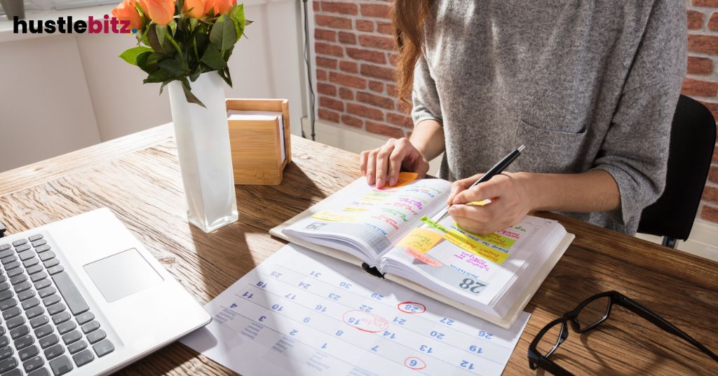 A woman doing writing and a laptop in the table with calendar