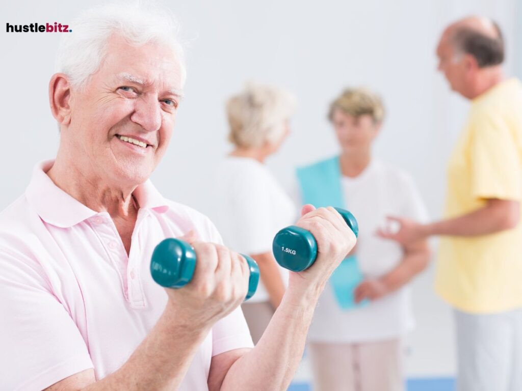 A smiling older man lifting dumbbells in a fitness class.