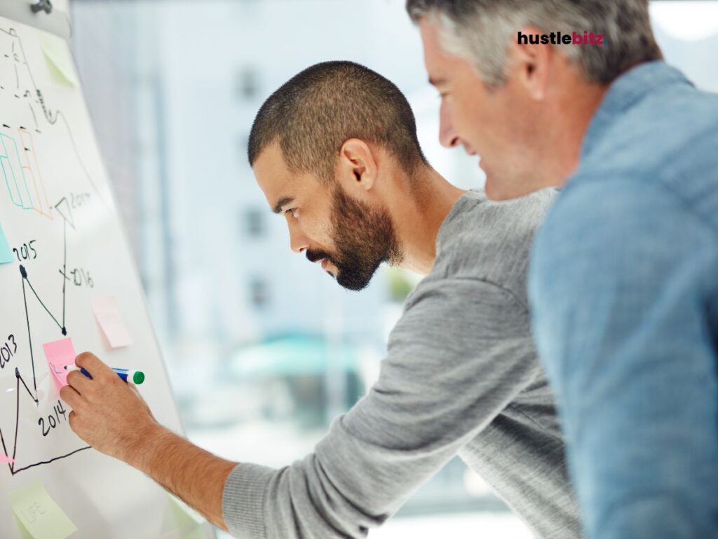 man holding a marker and writing on the white board