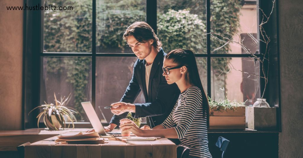 A man and a woman working together looking at the laptop.