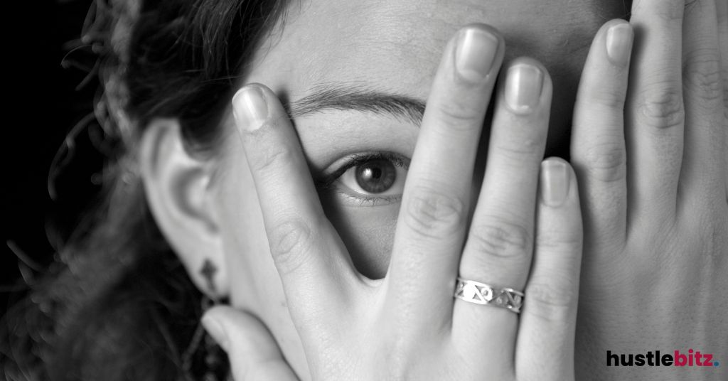 A woman peeking through her fingers.