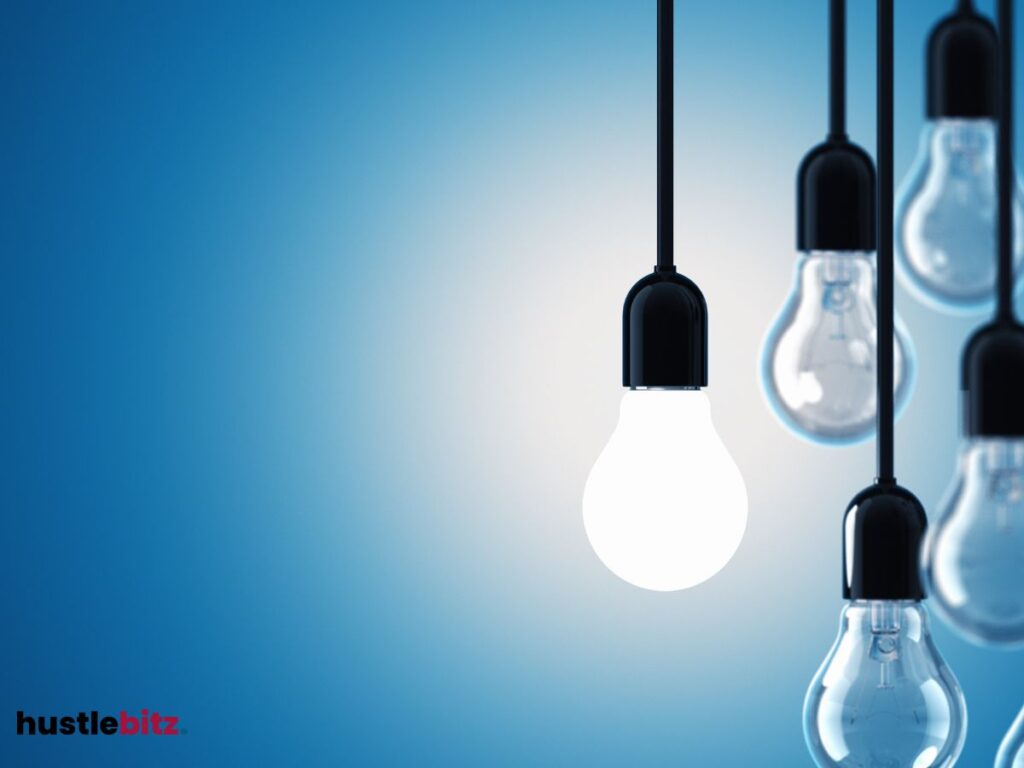 A lightbulb turned on with off light bulbs beside it.