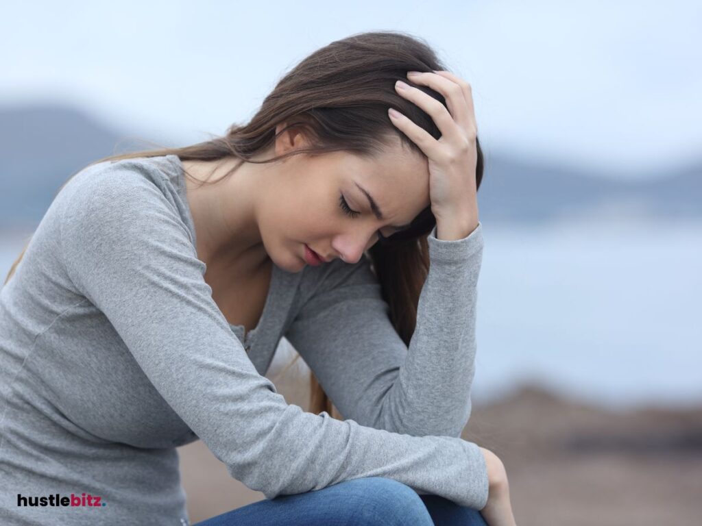 A woman hold her head and a lake background