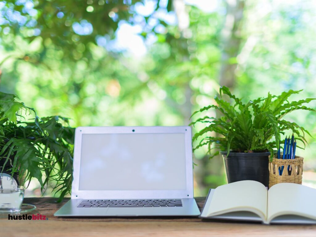 a laptop in the table and a book with a nature background