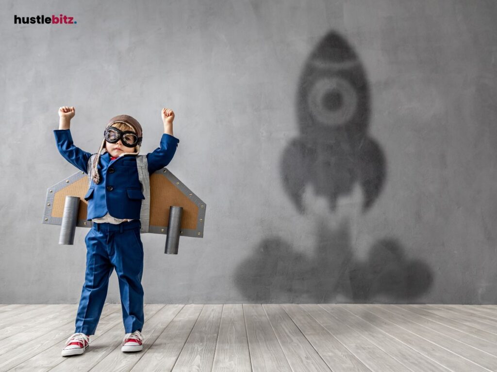 A child dressed as an astronaut, raising arms with a rocket shadow in the background.