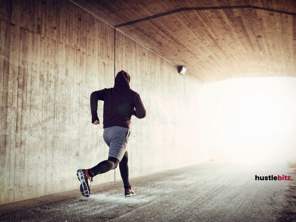 A man running through a tunnel toward the light at the end.