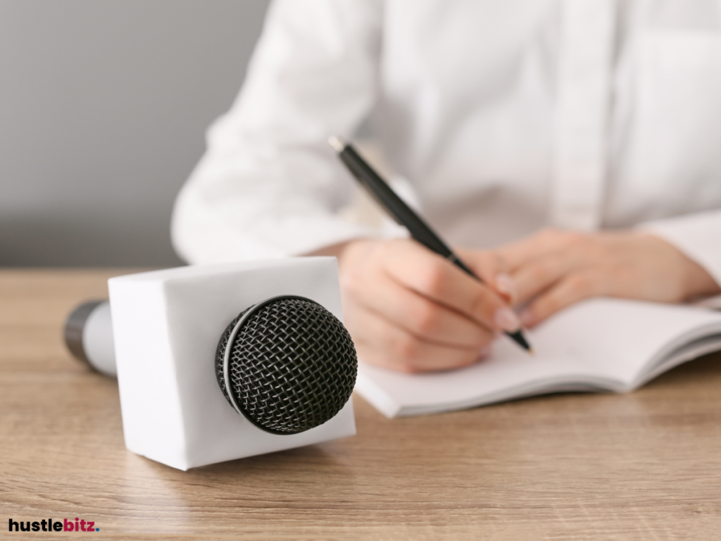 A person is preparing for an interview, with a microphone and a notepad.