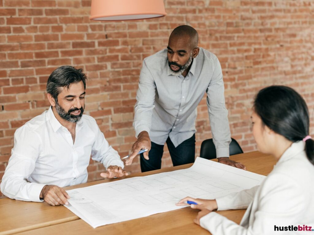 Three people having a meeting talking about the plan in  the table.