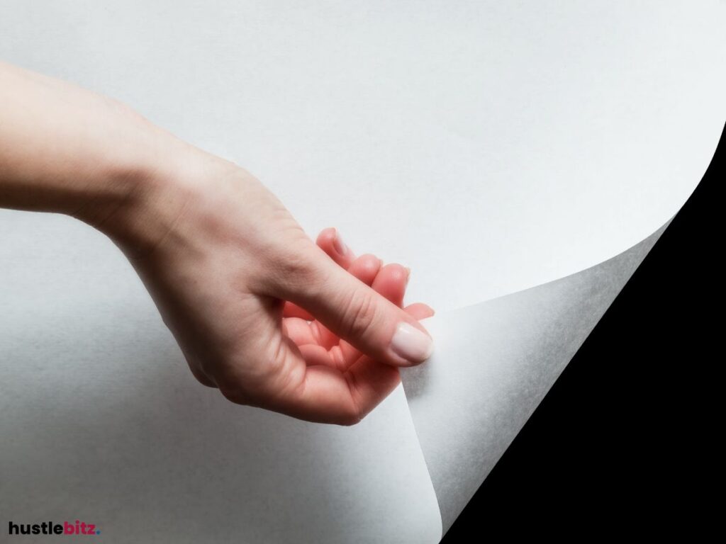  A hand turning a blank page, revealing a black background.