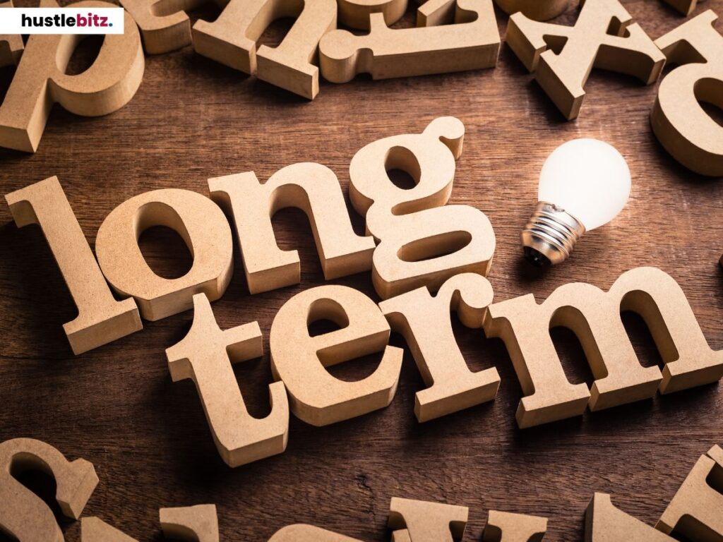 Wooden letters spelling "long term" with a glowing lightbulb.
