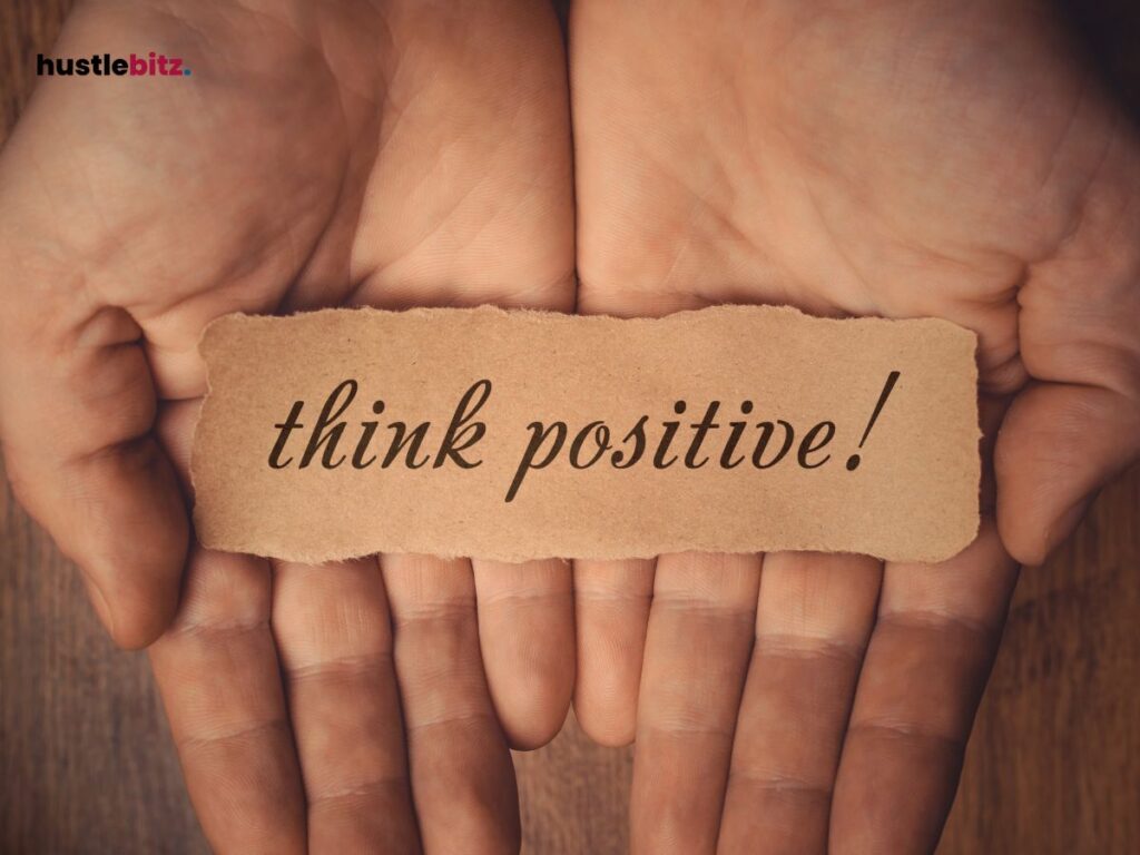 A hand holding a word "positive thinking