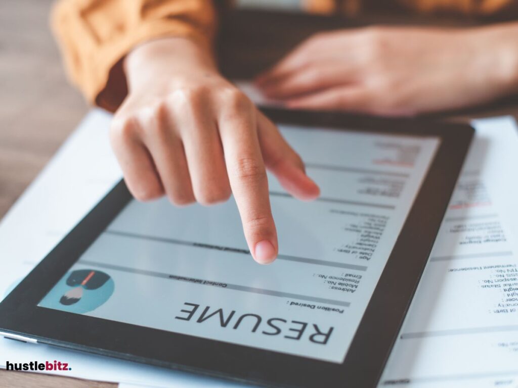 A hand pointing the tablet with a word resume