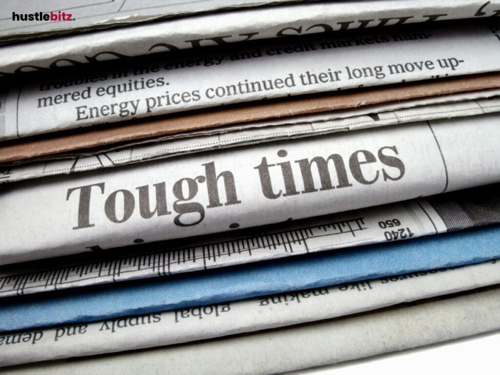 Folded newspapers with a bold "Tough Times" headline.