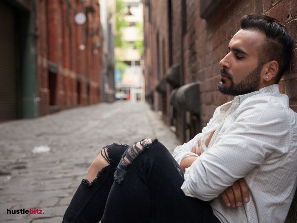 A man sitting beside the concrete wall in the street