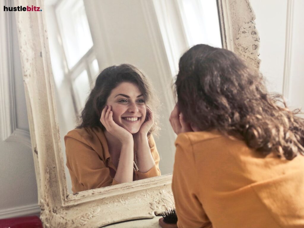 A woman smiling at herself in the mirror.