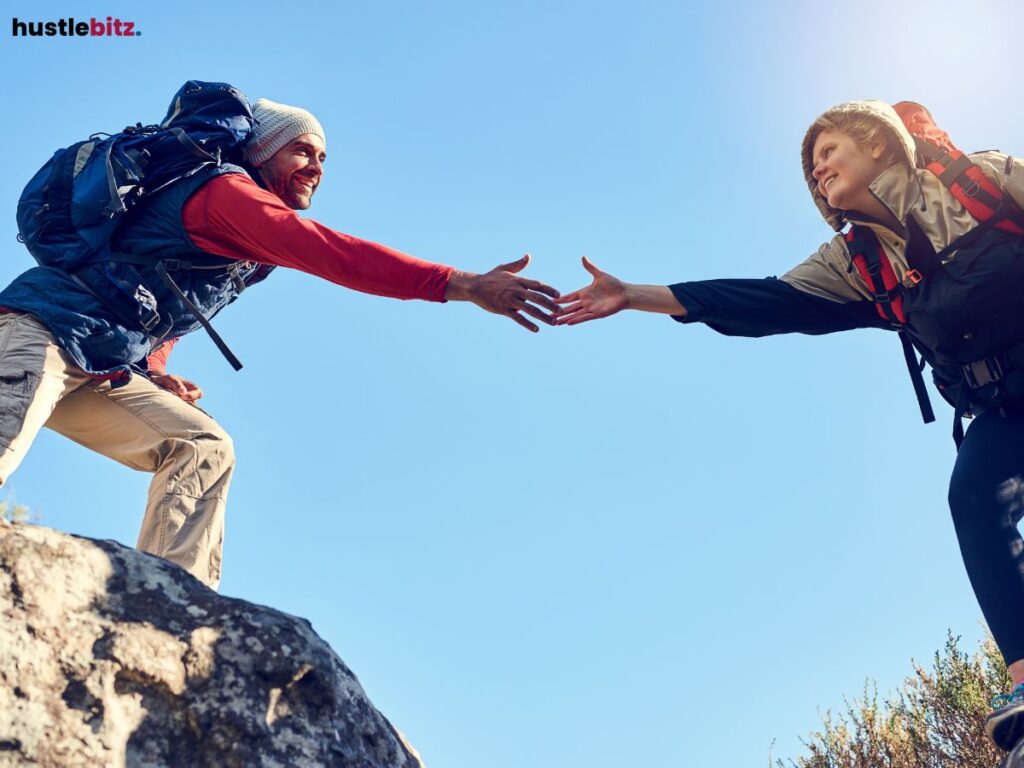 Hikers helping each other climb, symbolizing teamwork and support.